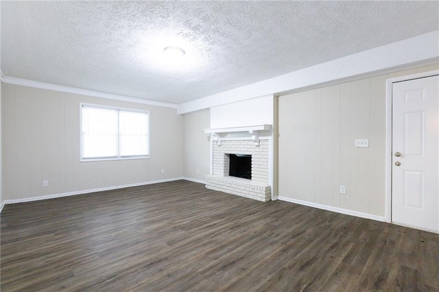 unfurnished living room featuring a brick fireplace, crown molding, dark hardwood / wood-style flooring, and a textured ceiling