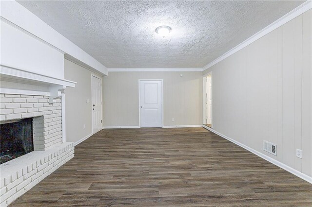 unfurnished living room with a fireplace, dark hardwood / wood-style floors, crown molding, and a textured ceiling