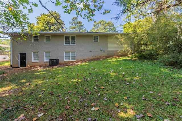 rear view of property featuring a yard and central AC