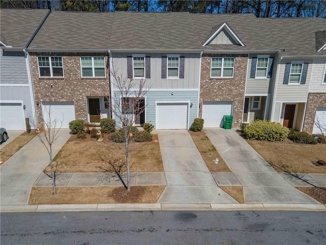 townhome / multi-family property featuring brick siding, board and batten siding, driveway, and a garage