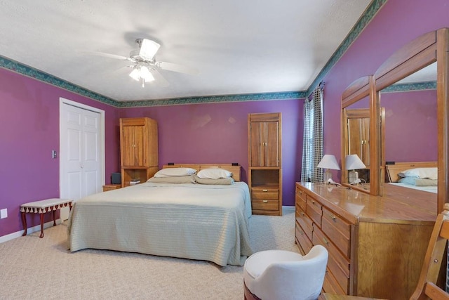 bedroom featuring a closet, light colored carpet, ceiling fan, and baseboards