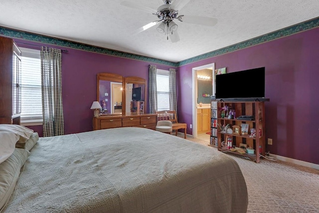 bedroom featuring carpet floors, connected bathroom, a textured ceiling, ceiling fan, and baseboards