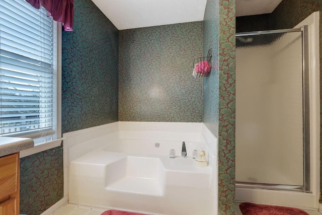 bathroom featuring a stall shower, a bath, and wallpapered walls