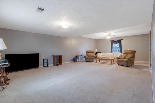 carpeted living room with baseboards, visible vents, ceiling fan, and a textured ceiling