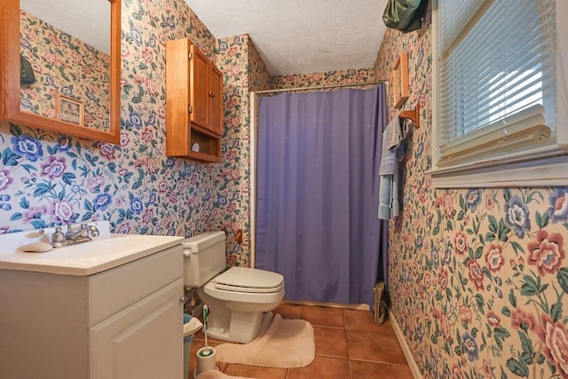 bathroom featuring wallpapered walls, toilet, tile patterned flooring, a textured ceiling, and vanity