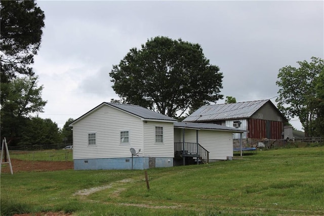 back of property featuring a yard