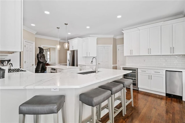 997 Thousand Oaks Bnd NW, Kennesaw, GA 30152 - kitchen featuring wine cooler, a sink, appliances with stainless steel finishes, crown molding, and a center island
