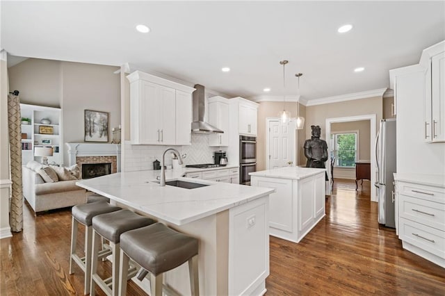 997 Thousand Oaks Bnd NW, Kennesaw, GA 30152 - kitchen featuring wall chimney range hood, a sink, stainless steel appliances, a center island, and dark wood finished floors