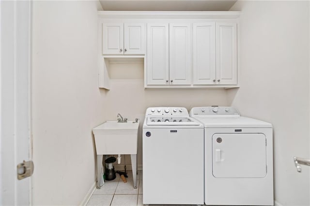 997 Thousand Oaks Bnd NW, Kennesaw, GA 30152 - laundry room with independent washer and dryer, cabinet space, light tile patterned floors, and baseboards