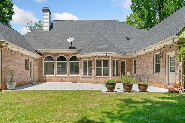 997 Thousand Oaks Bnd NW, Kennesaw, GA 30152 - back of property featuring brick siding, a patio, roof with shingles, and a yard