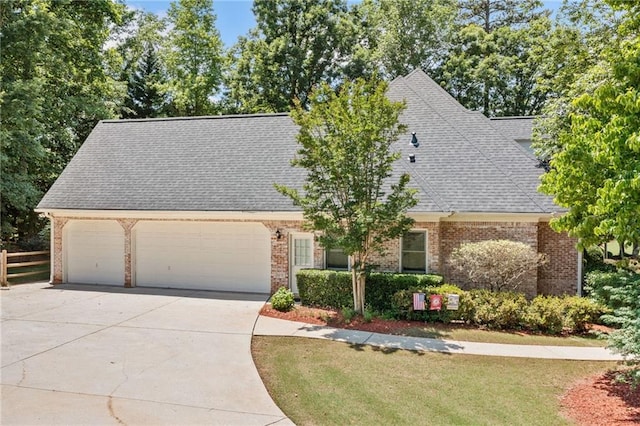 997 Thousand Oaks Bnd NW, Kennesaw, GA 30152 - view of front of house featuring an attached garage, driveway, brick siding, and a shingled roof