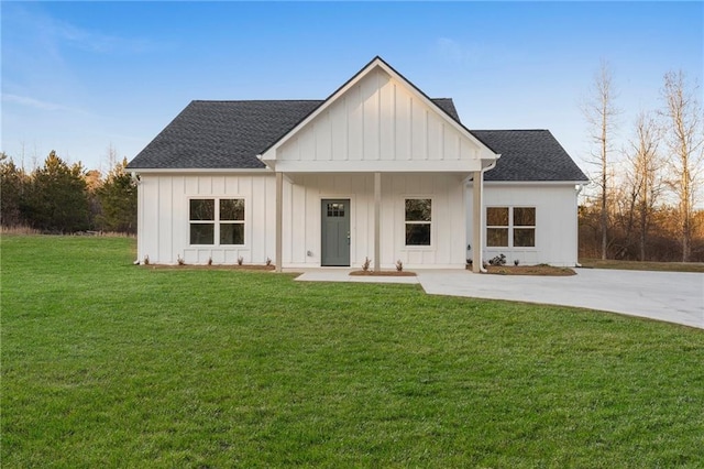 modern farmhouse style home with a front lawn and covered porch