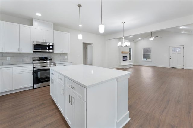 kitchen featuring stainless steel appliances, vaulted ceiling, and white cabinets