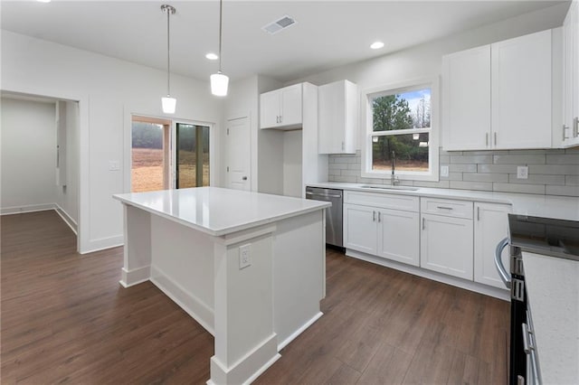 kitchen with appliances with stainless steel finishes, sink, white cabinets, and backsplash