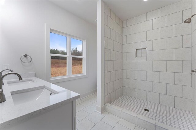 bathroom featuring vanity, tile patterned floors, and a tile shower