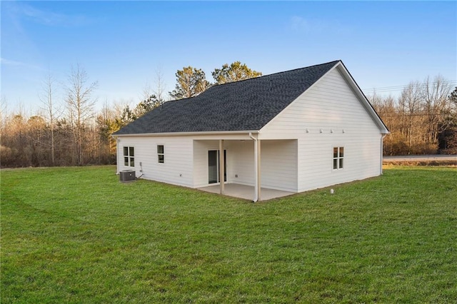 back of property with central AC, a lawn, and a patio area