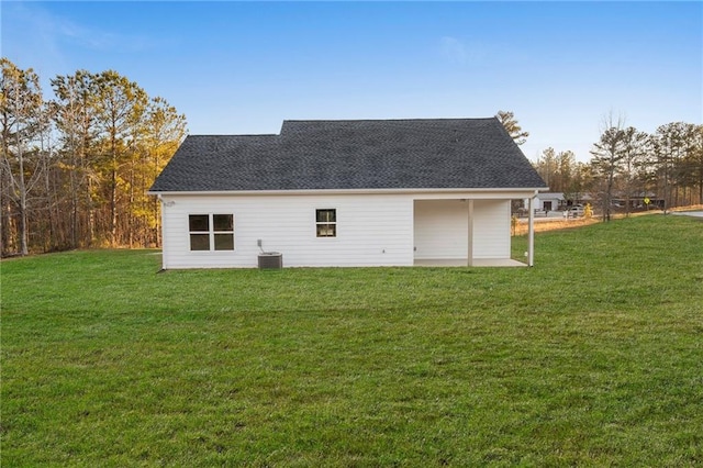 view of outbuilding with cooling unit and a lawn