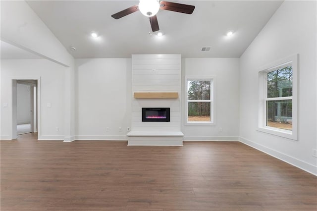 unfurnished living room with ceiling fan, lofted ceiling, a large fireplace, and dark hardwood / wood-style flooring