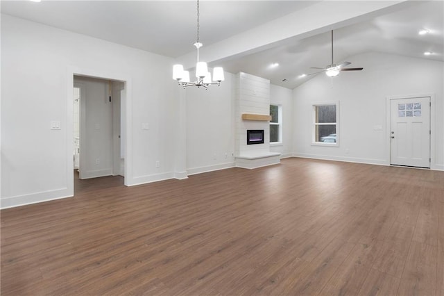 unfurnished living room featuring vaulted ceiling with beams, ceiling fan with notable chandelier, a large fireplace, and dark hardwood / wood-style flooring