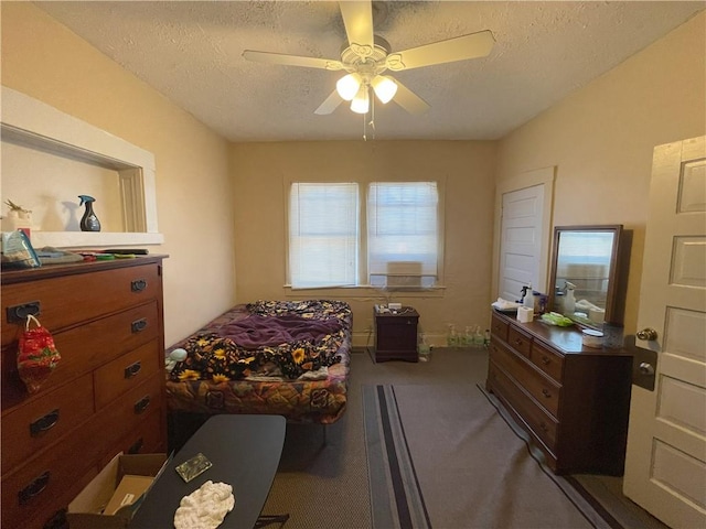 carpeted bedroom with a textured ceiling and a ceiling fan