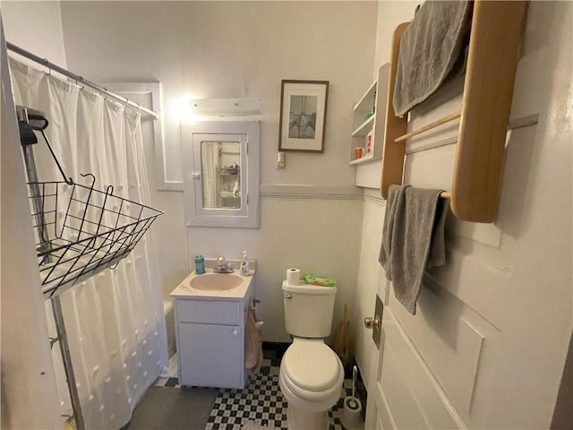 bathroom with curtained shower, toilet, and vanity