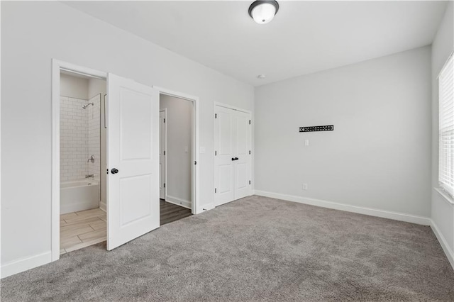2631 Creekside Dr NW, Atlanta, GA 30318 - unfurnished bedroom with carpet floors, baseboards, connected bathroom, and a closet