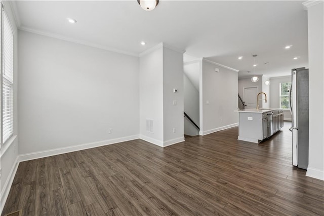 2631 Creekside Dr NW, Atlanta, GA 30318 - unfurnished living room featuring dark wood-type flooring, recessed lighting, baseboards, crown molding, and a sink
