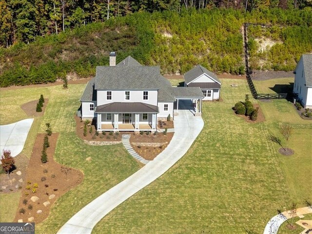 rear view of property featuring a lawn and a garage