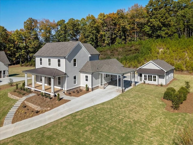 view of front of property featuring concrete driveway, a porch, a front lawn, and roof with shingles