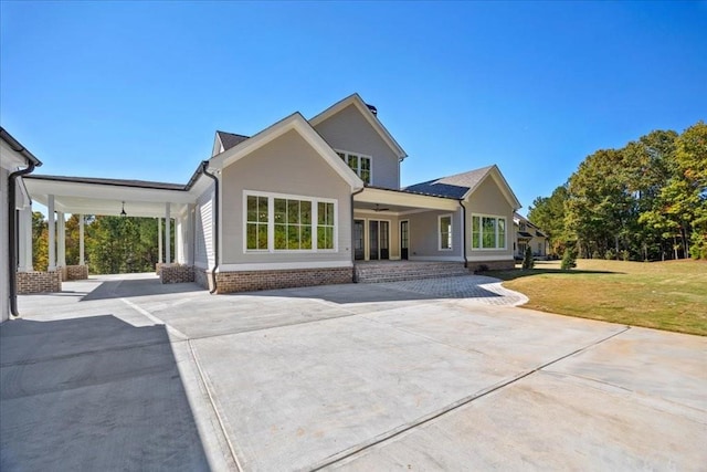 rear view of property featuring a yard and driveway