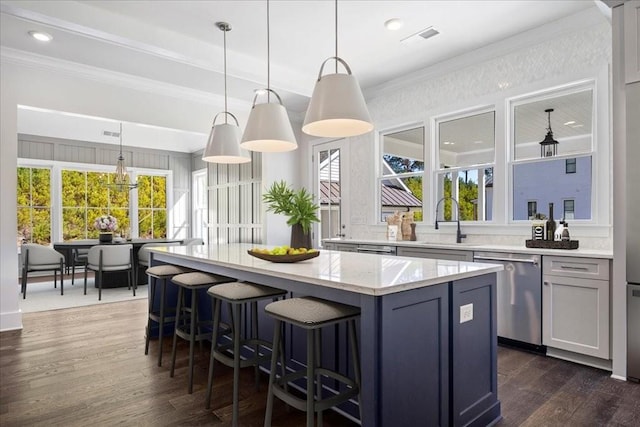 kitchen featuring stainless steel dishwasher, ornamental molding, dark wood-type flooring, a sink, and a kitchen island