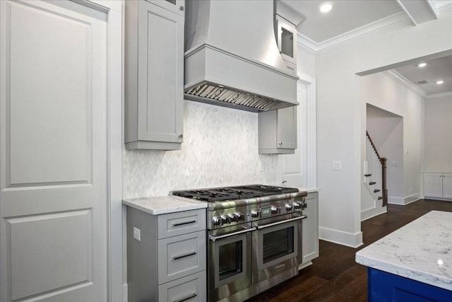 kitchen with decorative backsplash, ornamental molding, dark wood-type flooring, double oven range, and premium range hood