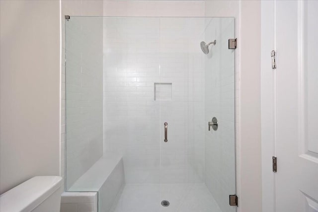 full bath with toilet and a stall shower