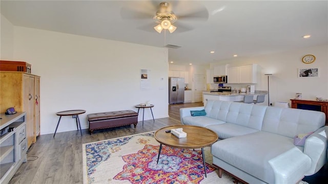 living room featuring ceiling fan and light hardwood / wood-style floors