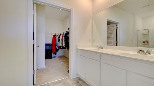 bathroom with dual sinks, tile flooring, and vanity with extensive cabinet space