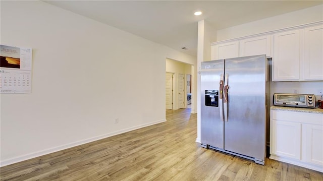 kitchen featuring white cabinets, stainless steel fridge, and light wood-type flooring