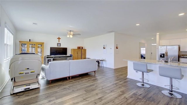 living room featuring sink, ceiling fan, and hardwood / wood-style floors