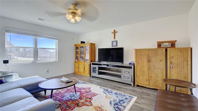 living room featuring light wood-type flooring and ceiling fan