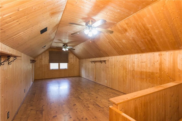 bonus room featuring wood ceiling, wood-type flooring, wooden walls, vaulted ceiling, and ceiling fan