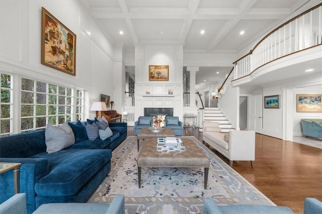 living room featuring a large fireplace, a towering ceiling, and a decorative wall
