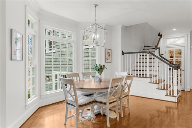 dining space with baseboards, a chandelier, stairs, ornamental molding, and wood finished floors