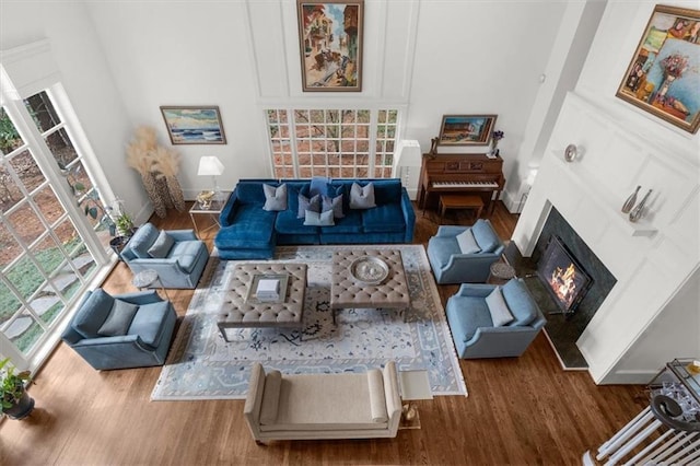 living area with a fireplace with flush hearth, baseboards, and wood finished floors