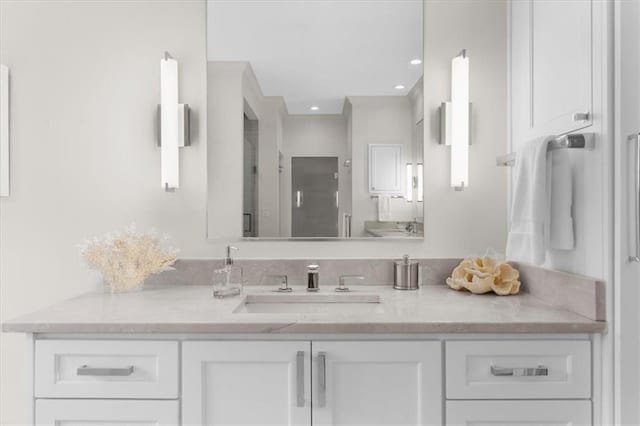 bathroom featuring recessed lighting, a shower stall, and vanity