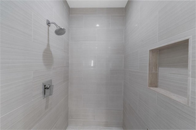 interior details with a tile shower