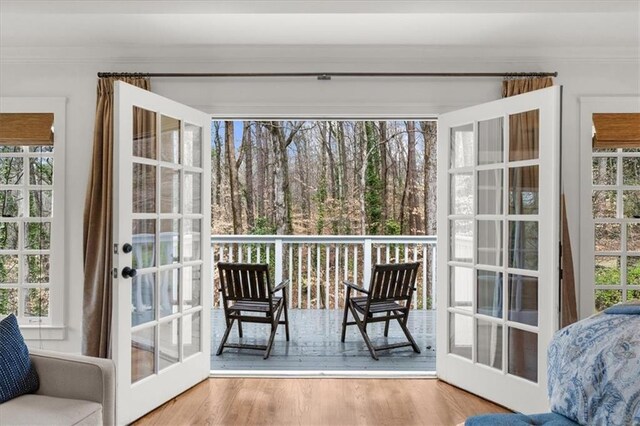 entryway with crown molding, wood finished floors, and a healthy amount of sunlight