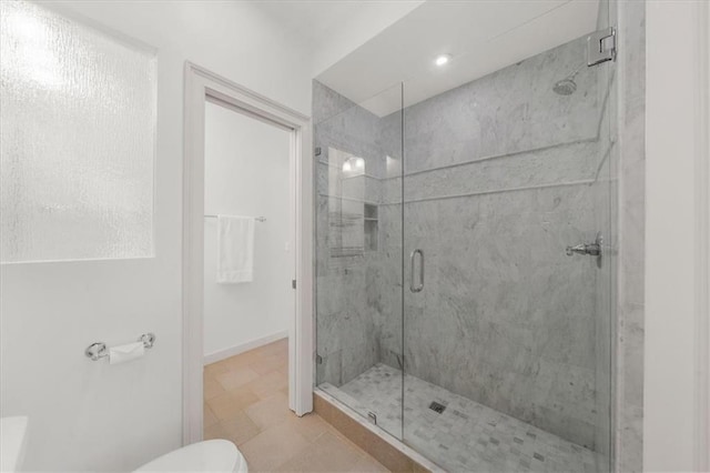 full bathroom with a shower stall, toilet, and baseboards