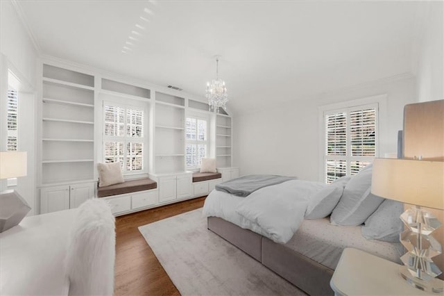 bedroom featuring visible vents, a notable chandelier, and wood finished floors