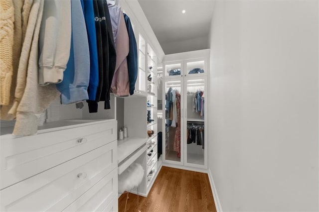 walk in closet with dark wood-style flooring
