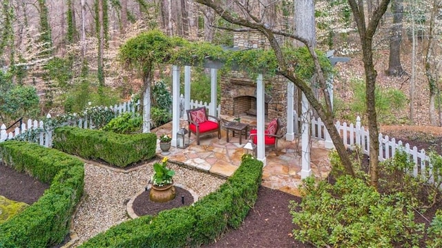 view of yard with an outdoor stone fireplace, a patio, and fence