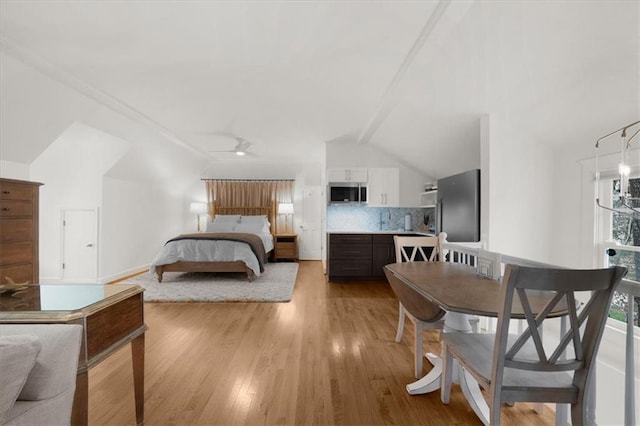 bedroom featuring vaulted ceiling, refrigerator, and light wood-style floors